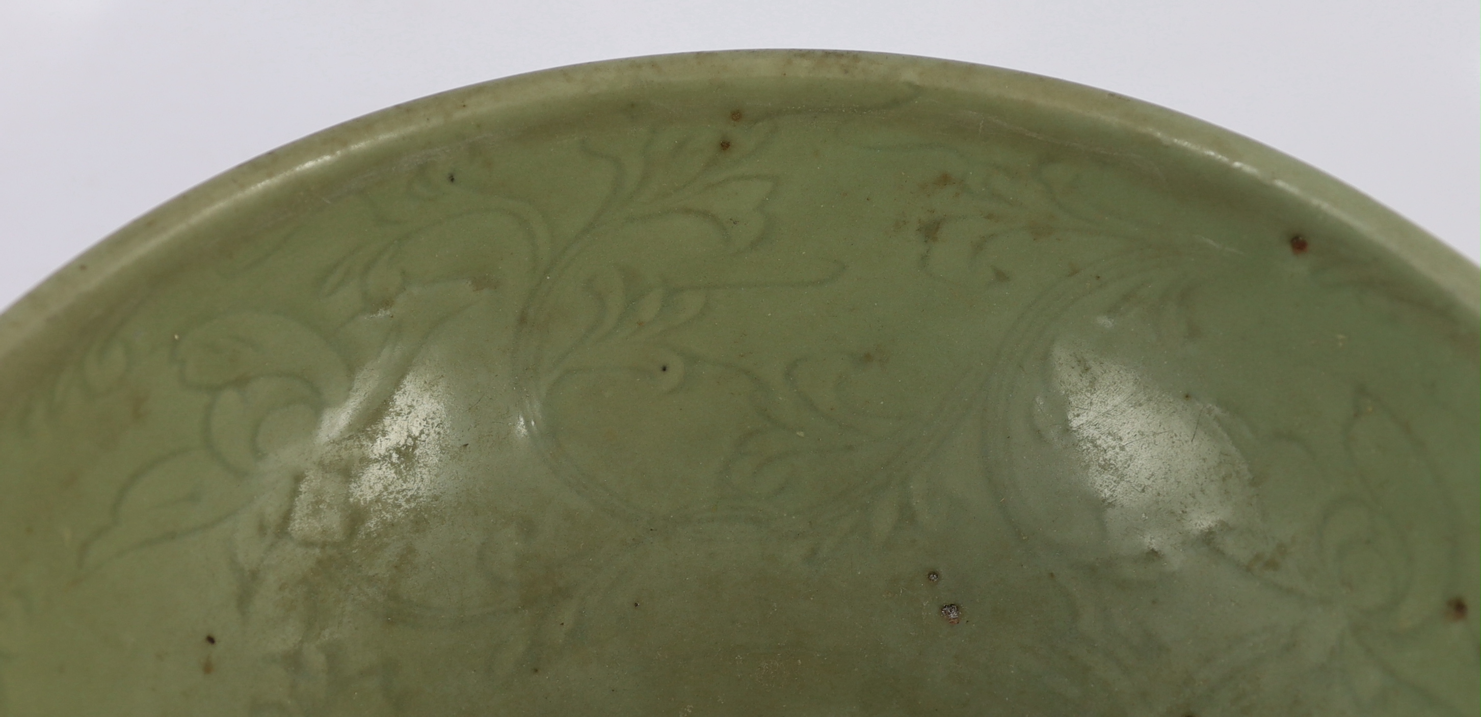 A large Chinese Ming carved Longquan celadon deep bowl, first half 15th century, scratches to glaze